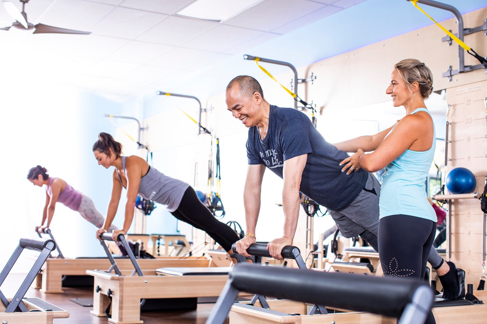 Men in women on Pilates Reformers in Club Pilates studio