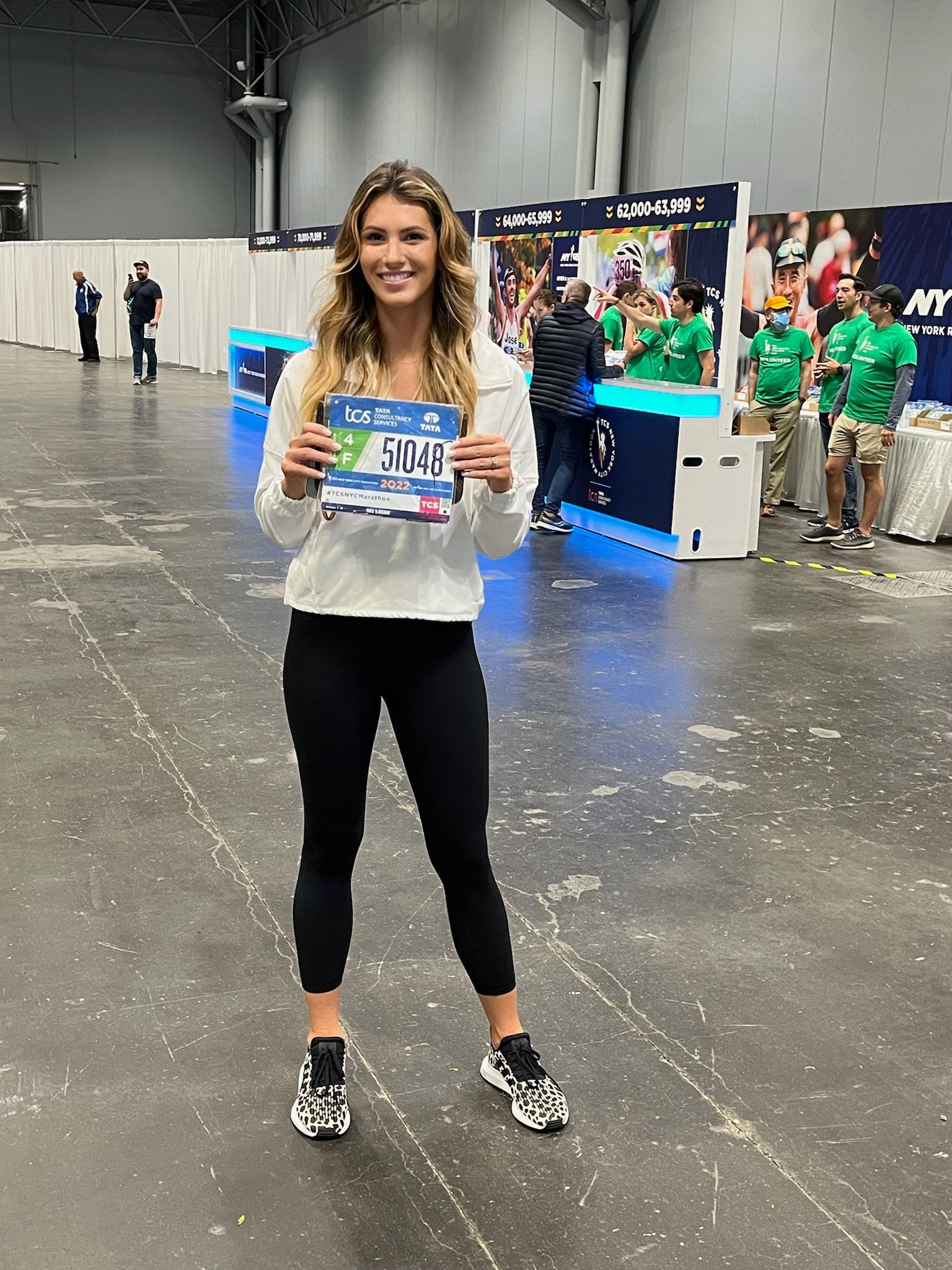Club Pilates member holding her marathon tag