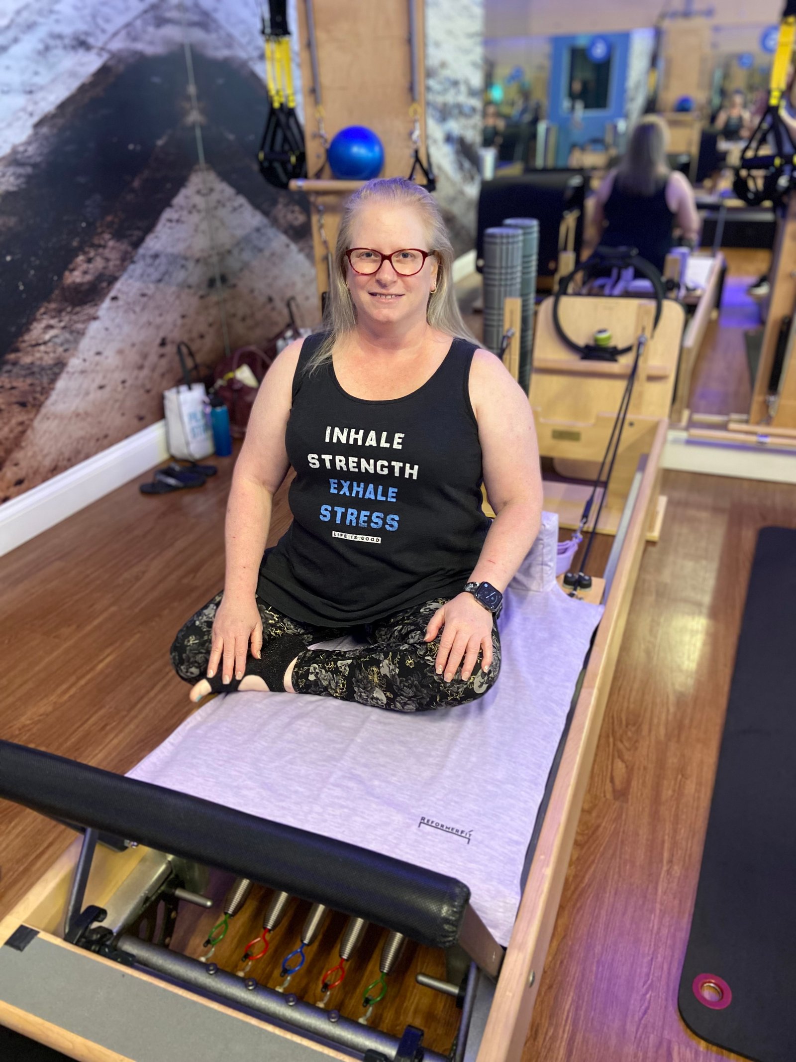 Middle aged woman on Pilates reformer in Pilates studio